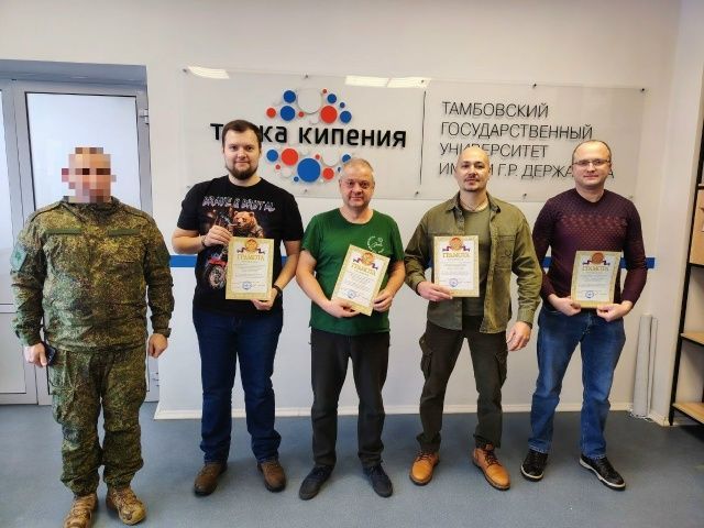 Сотрудники бюро позируют с военным